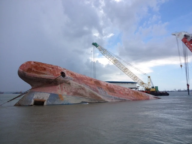 A sinking boat with the bottom of the hull facing up out of the water